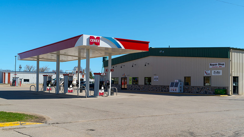 Wide view of the Middle River Co-op Oil Cenex station, showing the fuel canopy, store entrance, and ice freezer
